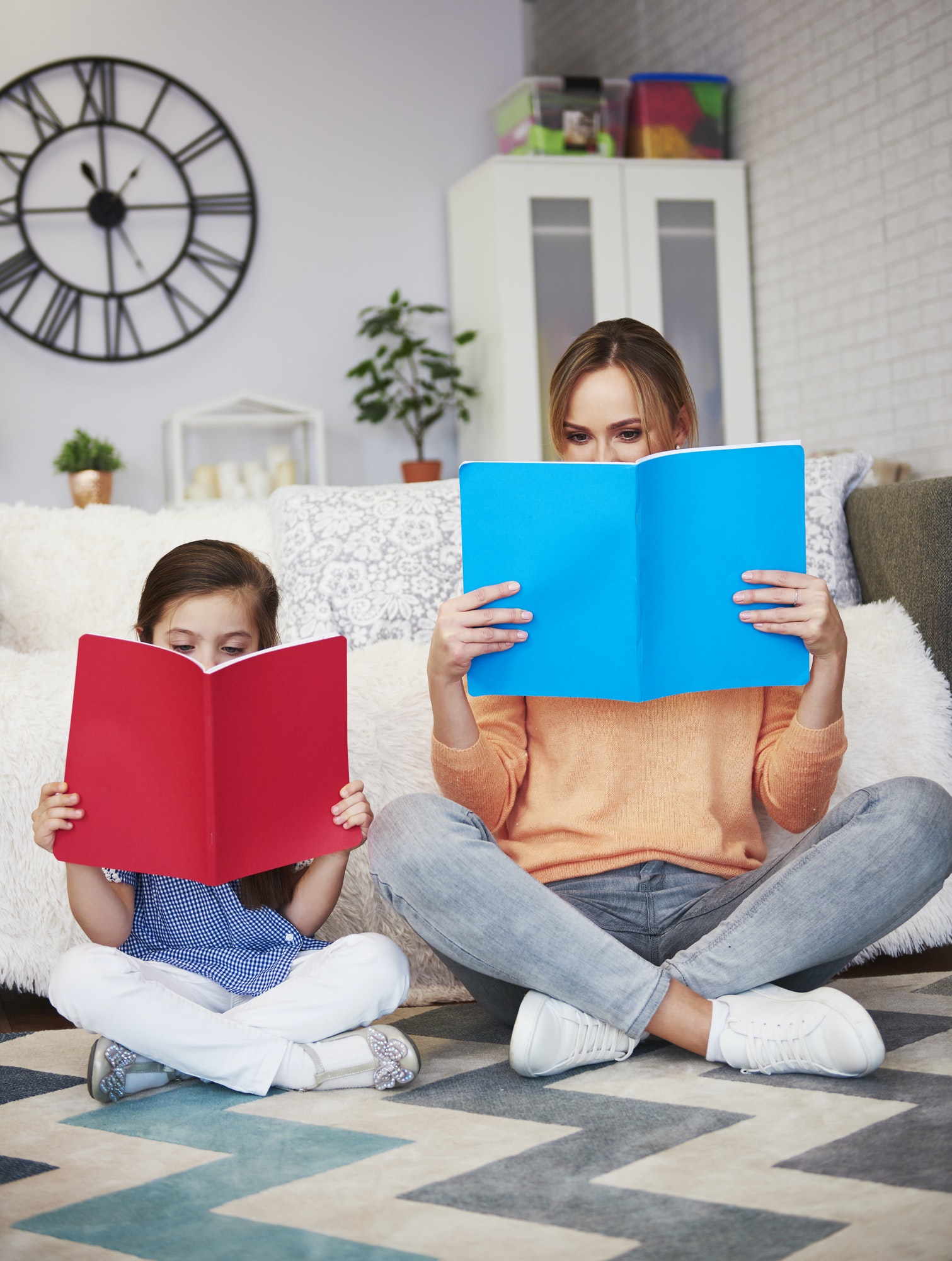 Mom and child reading a book in living room