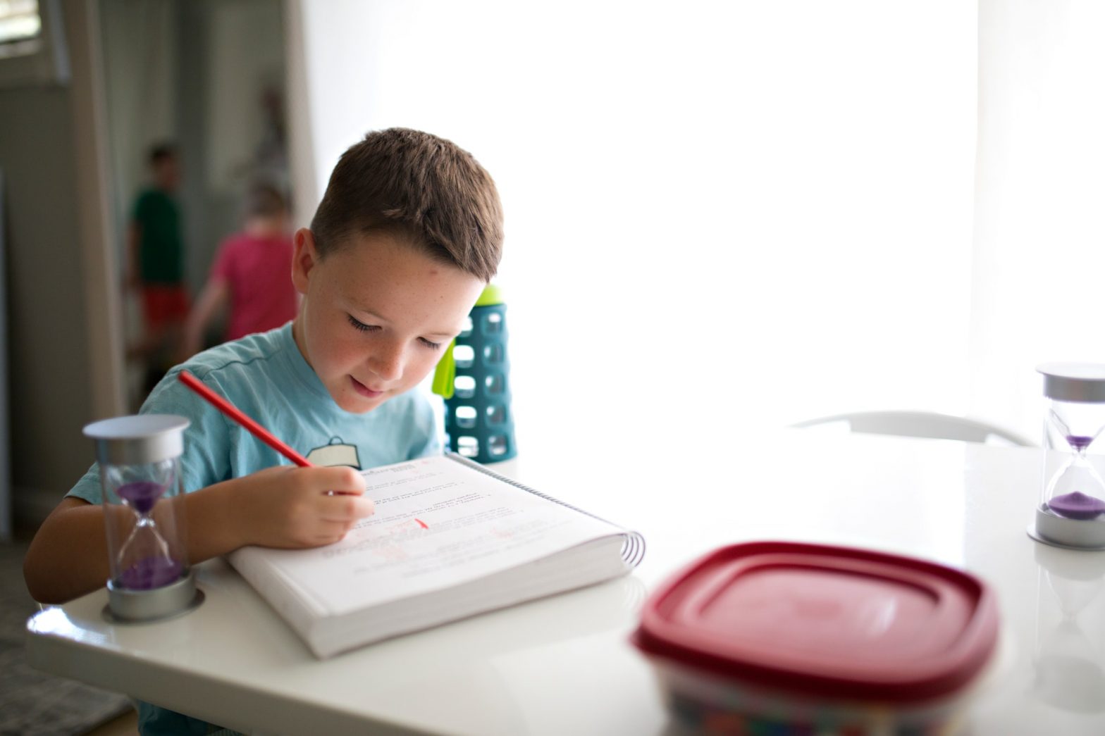 boy doing homework at home at a kitchen table