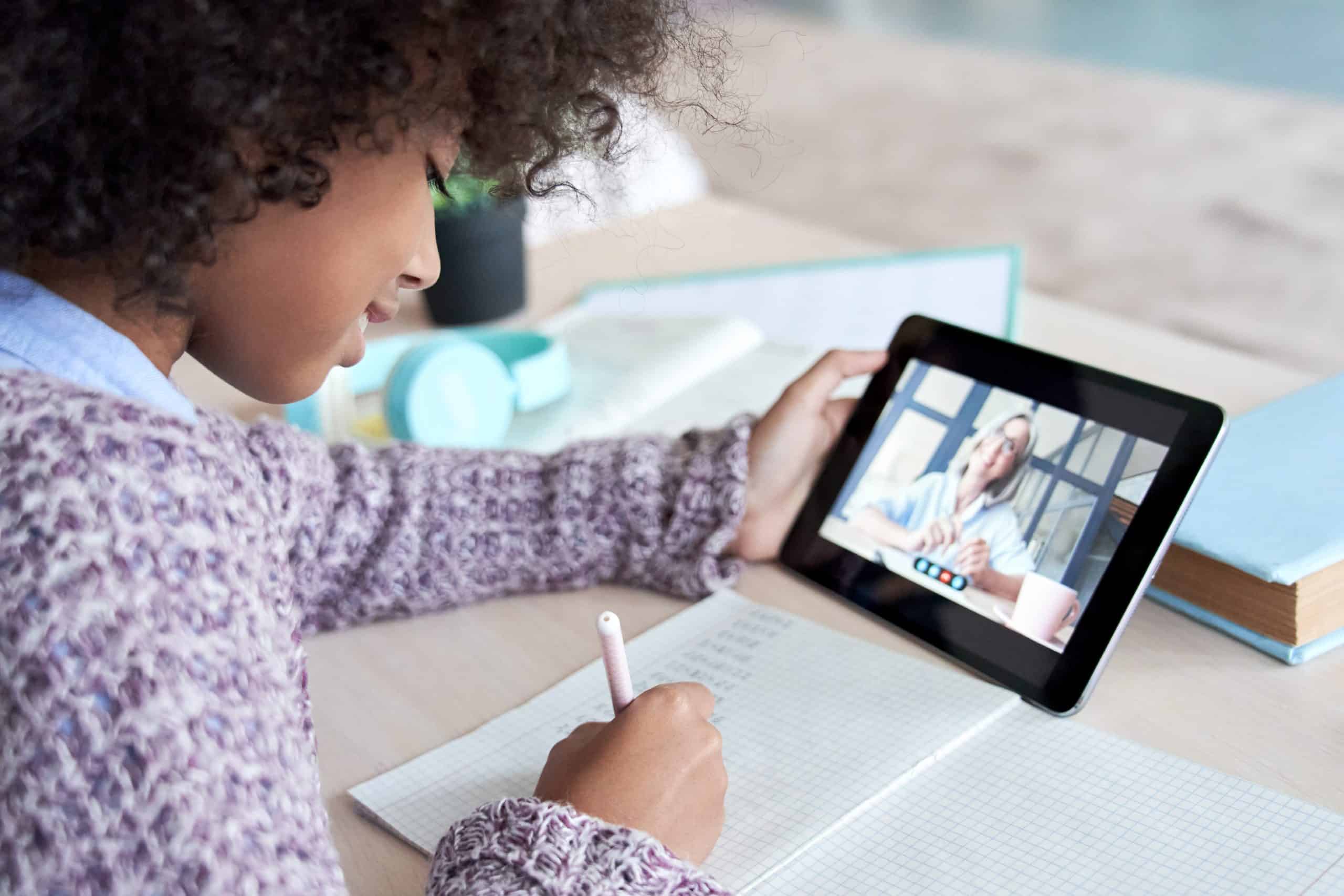 Registering is not Committing Geek School Tutoring Ltd A young girl writing while holding a tablet